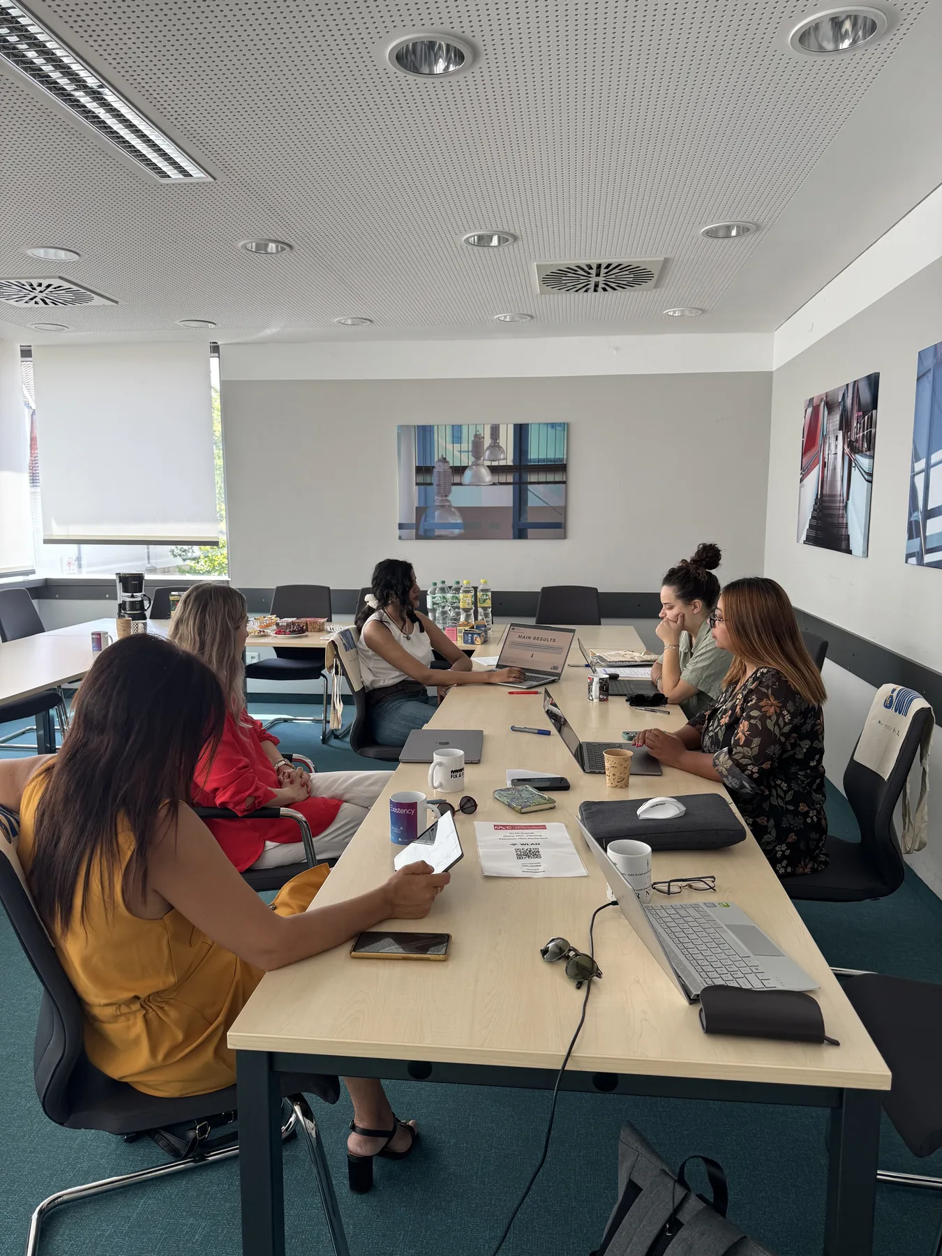 Partners discussing project coordination around a meeting table during the Invest in Youth kick-off in Erlangen.